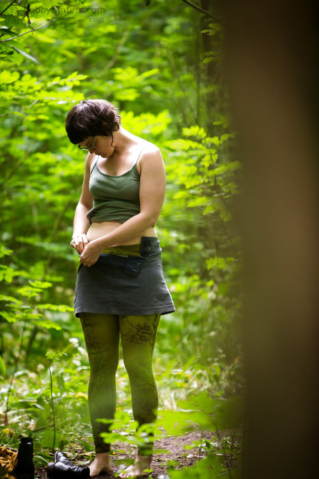 Voyeur snaps of nude brunette lady chick in glasses getting dressed in woods