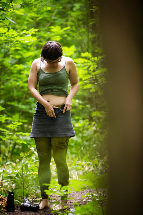 Voyeur snaps of nude brunette lady chick in glasses getting dressed in woods