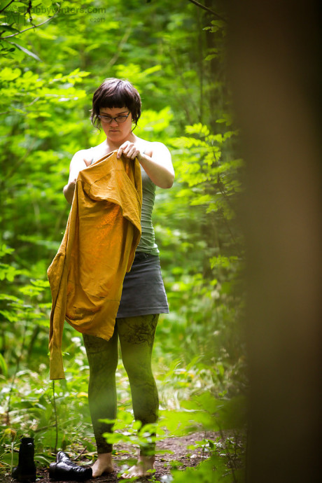 Voyeur snaps of nude brunette lady chick in glasses getting dressed in woods
