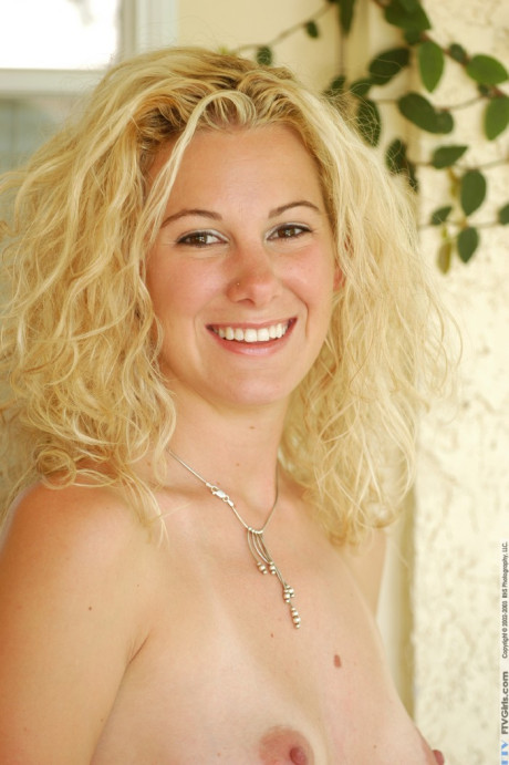 Blonde sweety Kelly exposes her big behind and poses nude in a solo