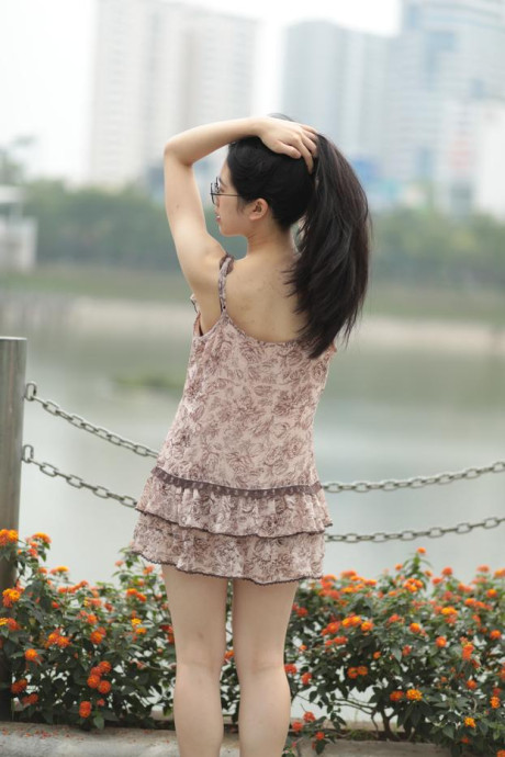 Good-looking chinese sexpot teases in a lovely short dress outdoors