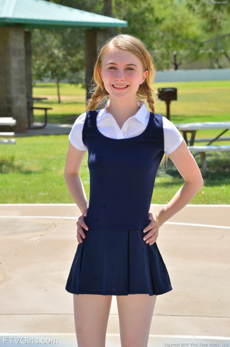 Tiny schoolgirl Sharlotte in uniform bends over for a nude upskirt outside