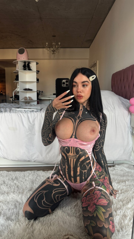Tattooed brunette plays with her nipples before taking self shots in a mirror
