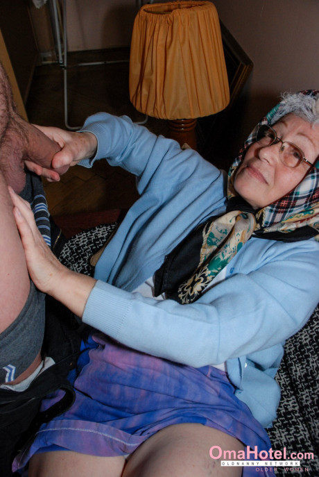 Attractive grandma with glasses Agnes strips and massages a nice fat meat