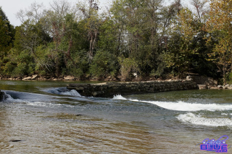 Natural ginger head Nicki Blue shows some leg while wading into a shallow stream
