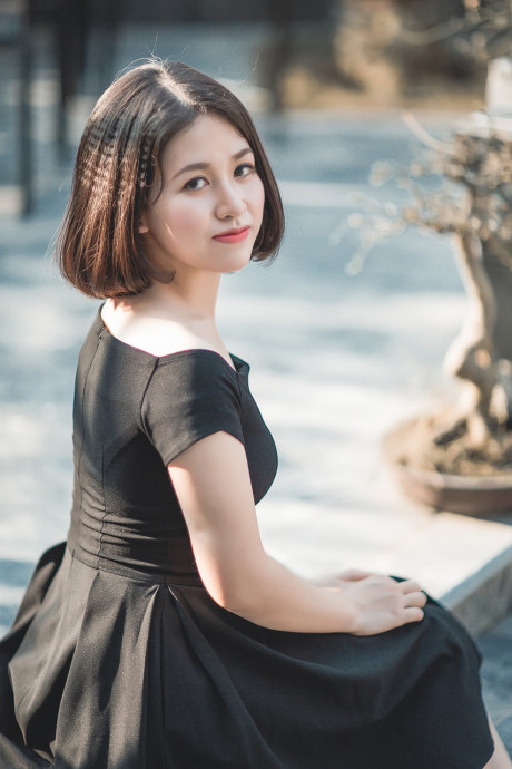 Glamorous chinese babe posing in her elegant ebony dress in public