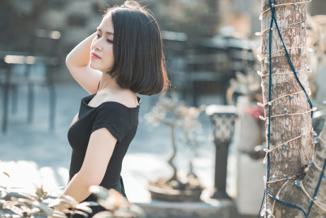 Glamorous chinese babe posing in her elegant ebony dress in public