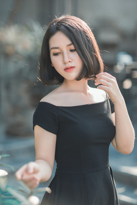 Glamorous chinese babe posing in her elegant ebony dress in public