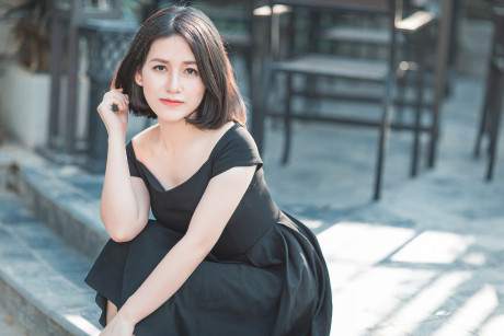 Glamorous chinese babe posing in her elegant ebony dress in public