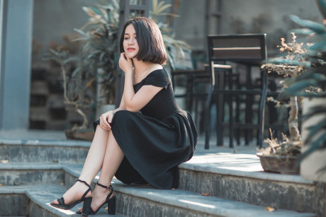 Glamorous chinese babe posing in her elegant ebony dress in public