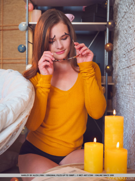 Nerdy slut girl broad Harley lights candles before getting totally undressed on a seat