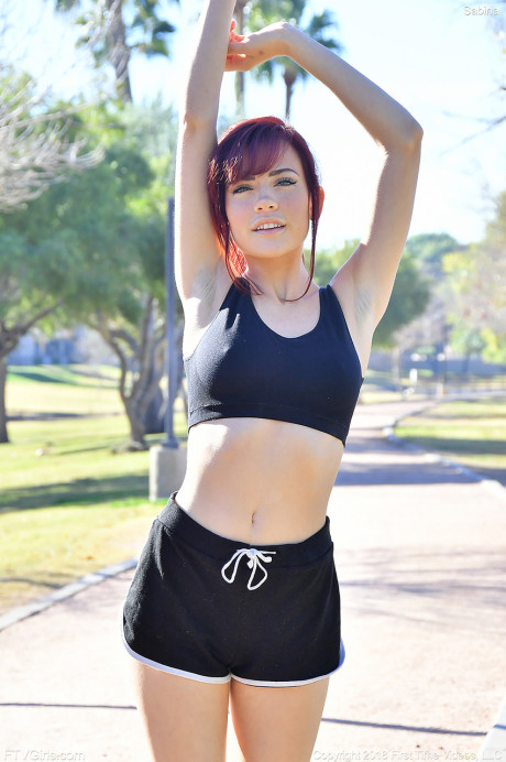 Frisky redhead teenie Sabina strips in public and does yoga butt naked