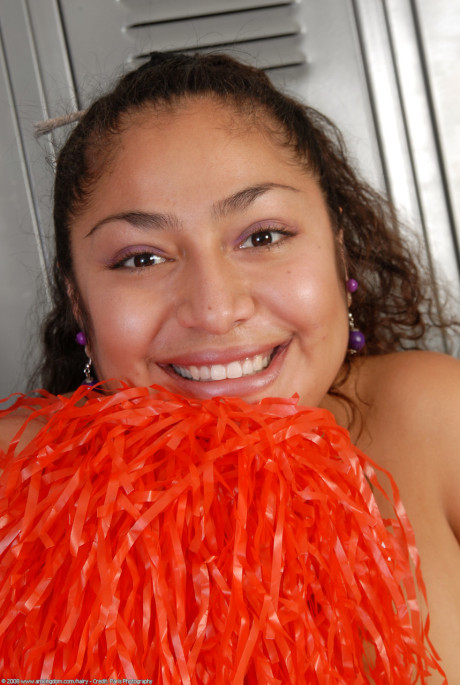 Petite curly haired cheerleader Reena shows her thick booty and bushy pussy