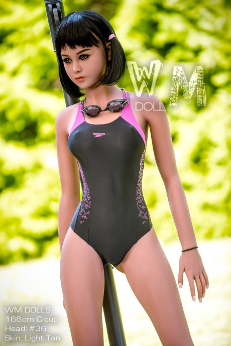 Raven-haired sex doll Clarice poses in her swimsuit and bare-breasted outdoors