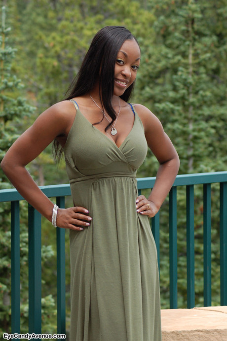 Black amateur Amber releases her giant boobs from a long dress on a balcony