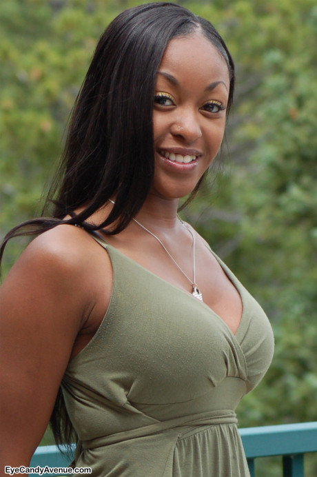 Black amateur Amber releases her giant boobs from a long dress on a balcony