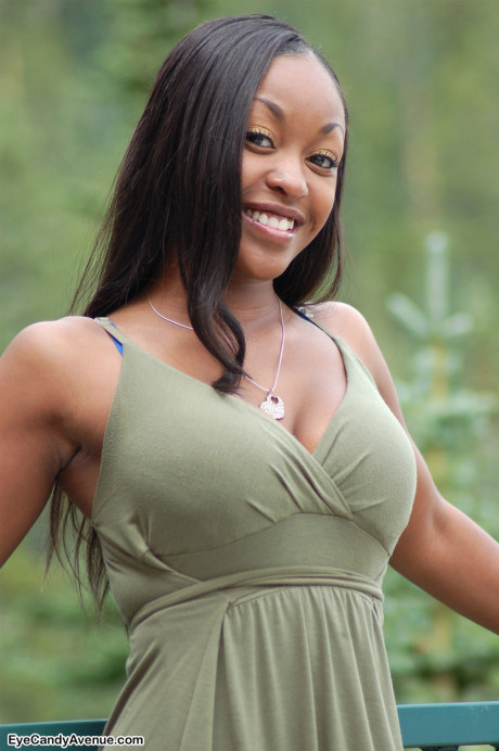 Black amateur Amber releases her giant boobs from a long dress on a balcony