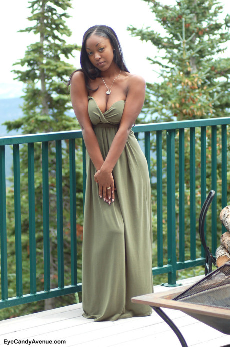 Black amateur Amber releases her giant boobs from a long dress on a balcony