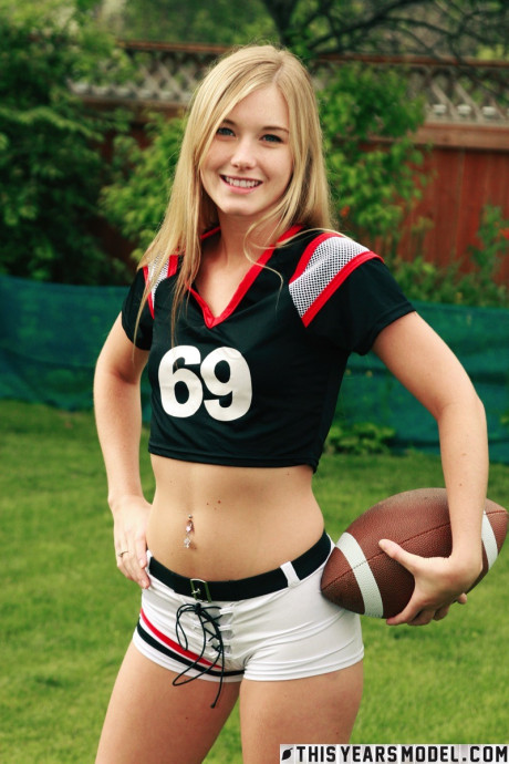 Pretty yellow-haired Jewel doffs sportswear to pose naked while holding a football