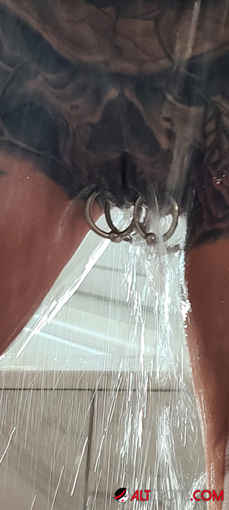 Tatted older chick Marie Bossette highlights her pierced snatch while showering