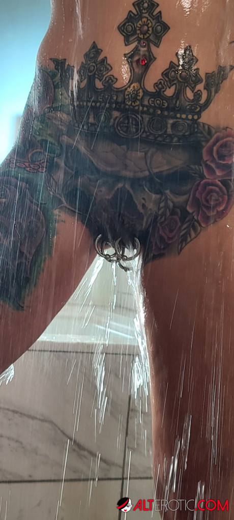 Tatted older chick Marie Bossette highlights her pierced snatch while showering