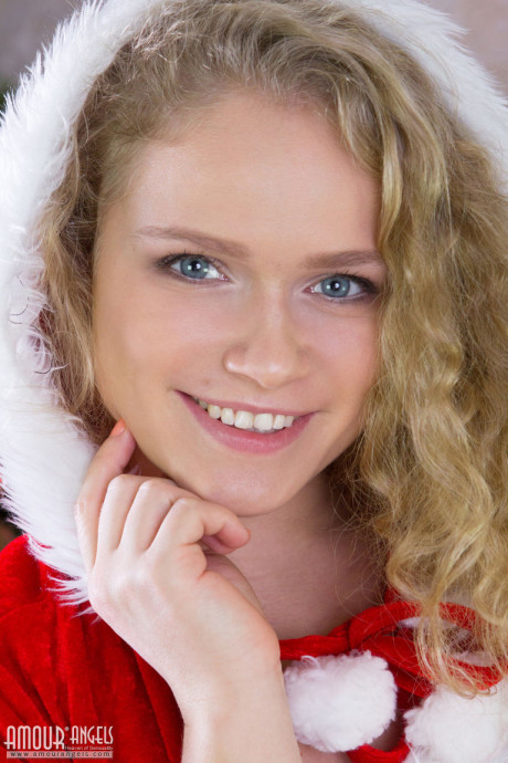 Pretty young lady girlfriend broad doffs her Christmas outfit for nude posing over the holidays